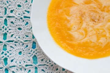 Pumpkin soup with sour cream and seeds on a wooden turquoise table. Selective focus, Still life, food and drink concept.