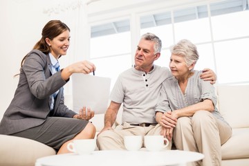 Businesswoman showing documents to senior couple