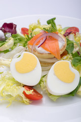 green salad with eggs in the shape of a heart, salmon, cherry tomatoes