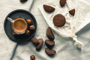 breakfast representation on white background with coffee espresso,chocolate biscuits, walnuts,hazelnuts,almonds,brazilian nuts and nutcracker, filtered with vintage colors