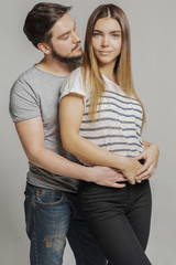 Fototapeta premium Casual loving couple on grey background