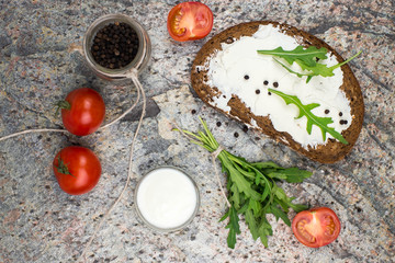 Healthy open sandwich with fresh cheese with arugula, tomato and pepper. overhead view.