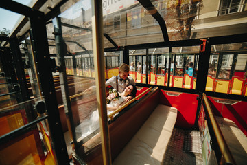 Bride and groom posing in a tour car