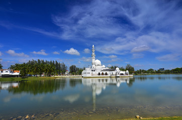 Fototapeta na wymiar Beautiful white mosque with reflection in the lake during clean