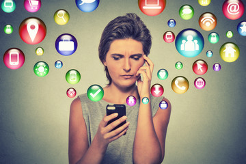 Confused woman using smartphone application icons flying out of cellphone