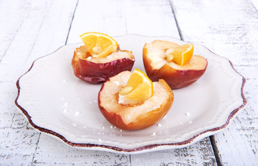 Baked apples on a plate with lemon and citrus puree of apples and pumpkins