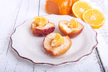 Baked apples on a plate with lemon and citrus puree of apples and pumpkins