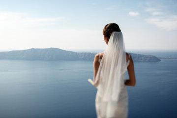 Fototapeta na wymiar Romantic beautiful bride in white dress posing on terrace with s