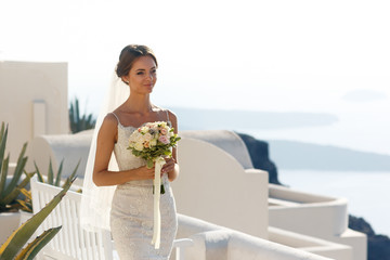 Beautiful brunette bride walking to wedding aisle with roses bou