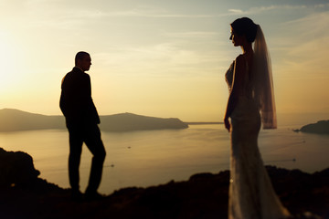 Married couple bride and groom posing at sunset in the mountains