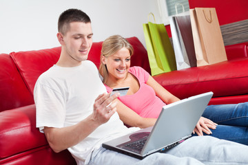 Happy couple shopping on internet at home