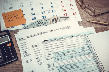 Tax form with calendar, pen, calculator, notepad and glasses. to