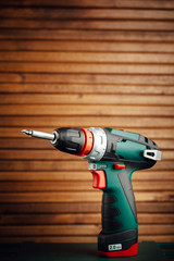cordless screwdriver against wooden background