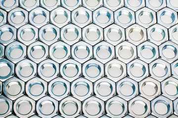 Nut screws tightly stacked next to each other on a flat surface. Nut background isolated on white.