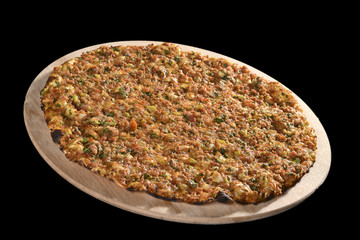Lahmacun is a round, thin piece of dough topped with minced meat and minced vegetables and herbs including onions, tomatoes and parsley, then baked. 