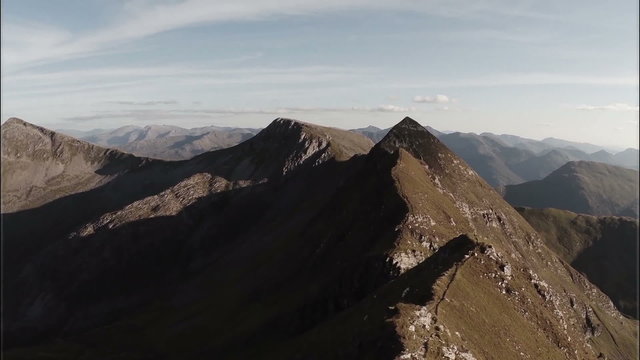 Spectacular aerial shot on Sgurr a'Mhaim mountain revealing devils ridge in the Scottish highlands during sunset
