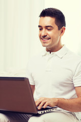 happy man working with laptop computer at home
