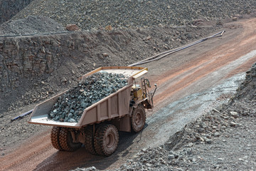 dumper truck with loaded stones driving along in a quary. mining