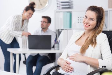 Obraz na płótnie Canvas Businesswoman with pregnant belly