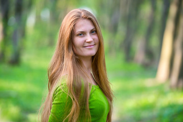 Fototapeta premium Pretty woman with red hair in the park