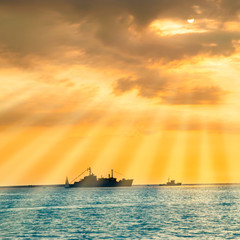 Sunset over blue sea with ship