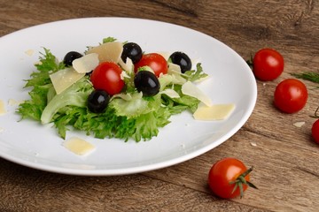Fresh vegetables salad with tomatoes , olives , parmesan cheese