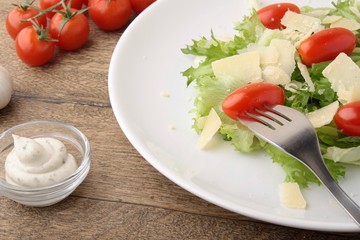 Fresh salad parmesan on a wooden background