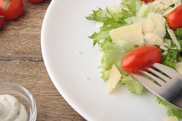 Fresh salad parmesan on a wooden background