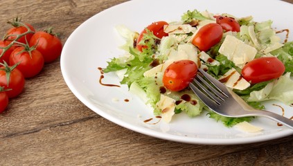 Fresh salad parmesan on a wooden background