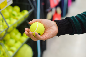 Hand holding tennis ball for a tennis court 