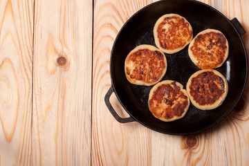 Beautiful golden cheese pancakes fried in a pan. Syrniki.