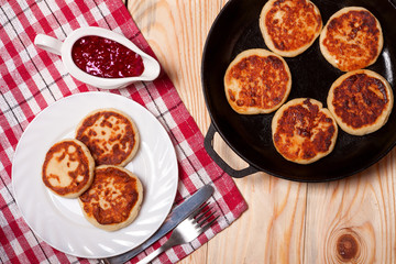 Beautiful golden cheese pancakes fried in a pan. Syrniki.