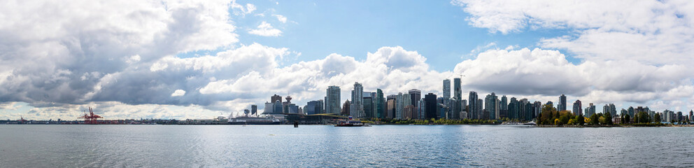 Fototapeta na wymiar skyline of vancouver city behind the sea during a sunny day of summer with a beautiful sky seen from stanley park british columbia canada 