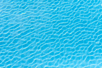 Blue swimming pool rippled water detail in the shining day 