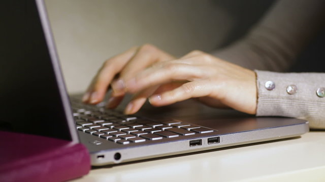 woman typing on a laptop in the office close up
