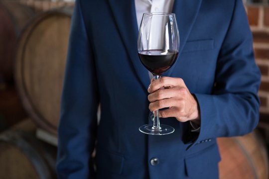 Well dressed man examining glass of wine