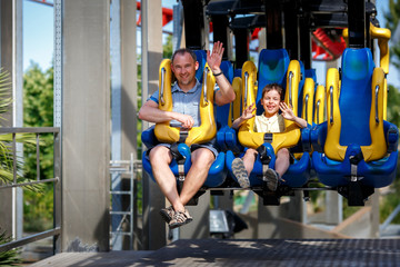 Father and his little son enjoy the ride at adventure park