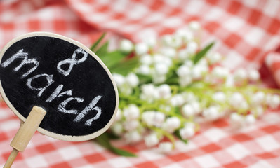 March 8 plate and flowers on blurred backdrop