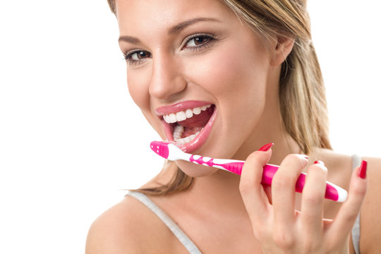 Woman holding toothbrush and  brushing teeth