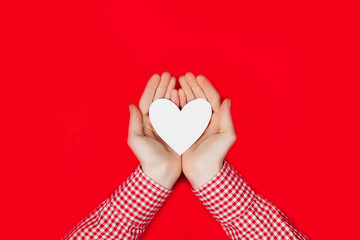 woman holding white heart on red