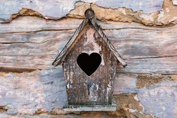 Drewniany domek z sercem na starych deskach
