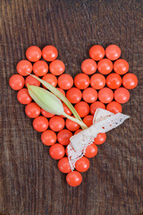 Heart of vitamins, vital heart for Valentines Day on wooden background.