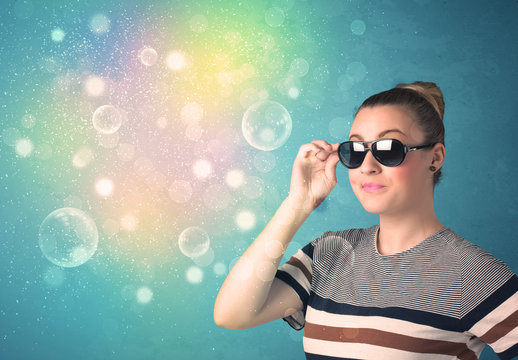 Young woman with sunglasses and bokeh colourful lights