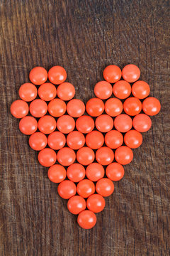 Heart of vitamins, vital heart for Valentines Day on wooden background.