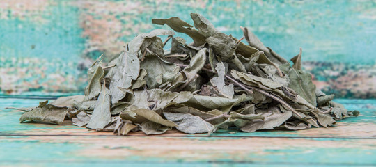 Dried curry leaves over wooden background