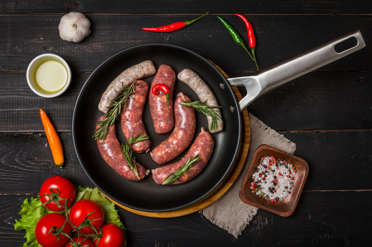 Raw sausages in a frying pan