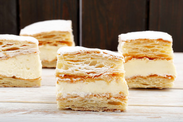 Puff pastry cake with cream and powdered sugar. Catering set.