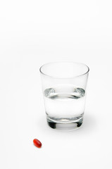 Glass of Water with Pill on White Background