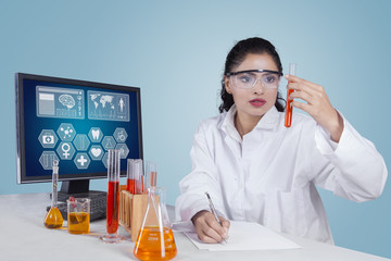 Indian researcher looking at test tube