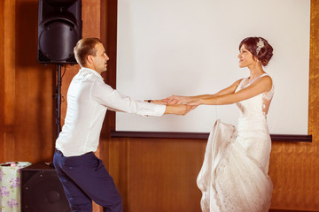 Portrait of young beautiful wedding couple dancing at restaraunt